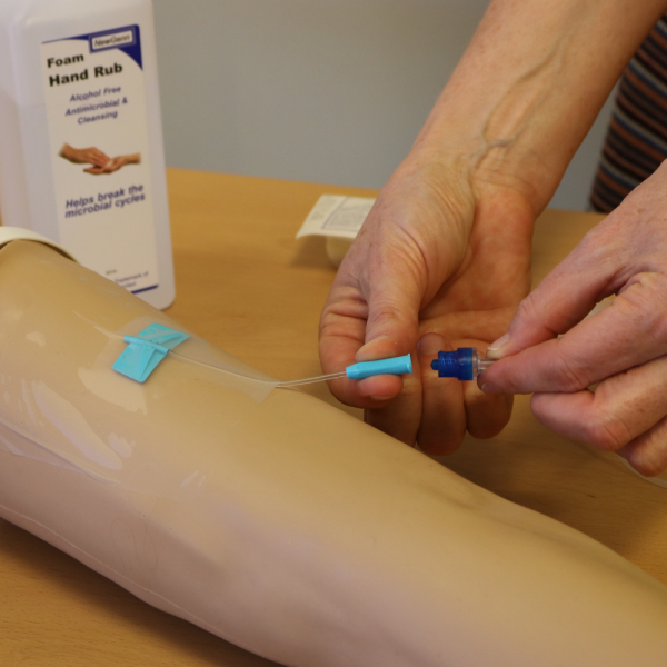 Applying medicine via a syringe pump to an arm.