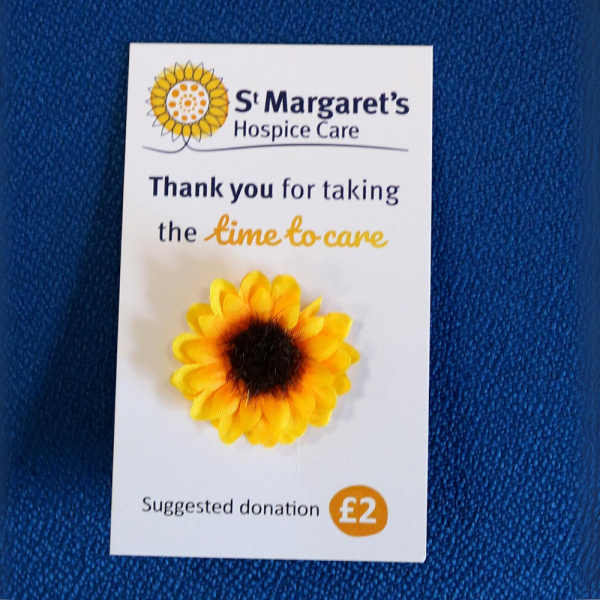 Small pin sunflower badge attached to a backing card.