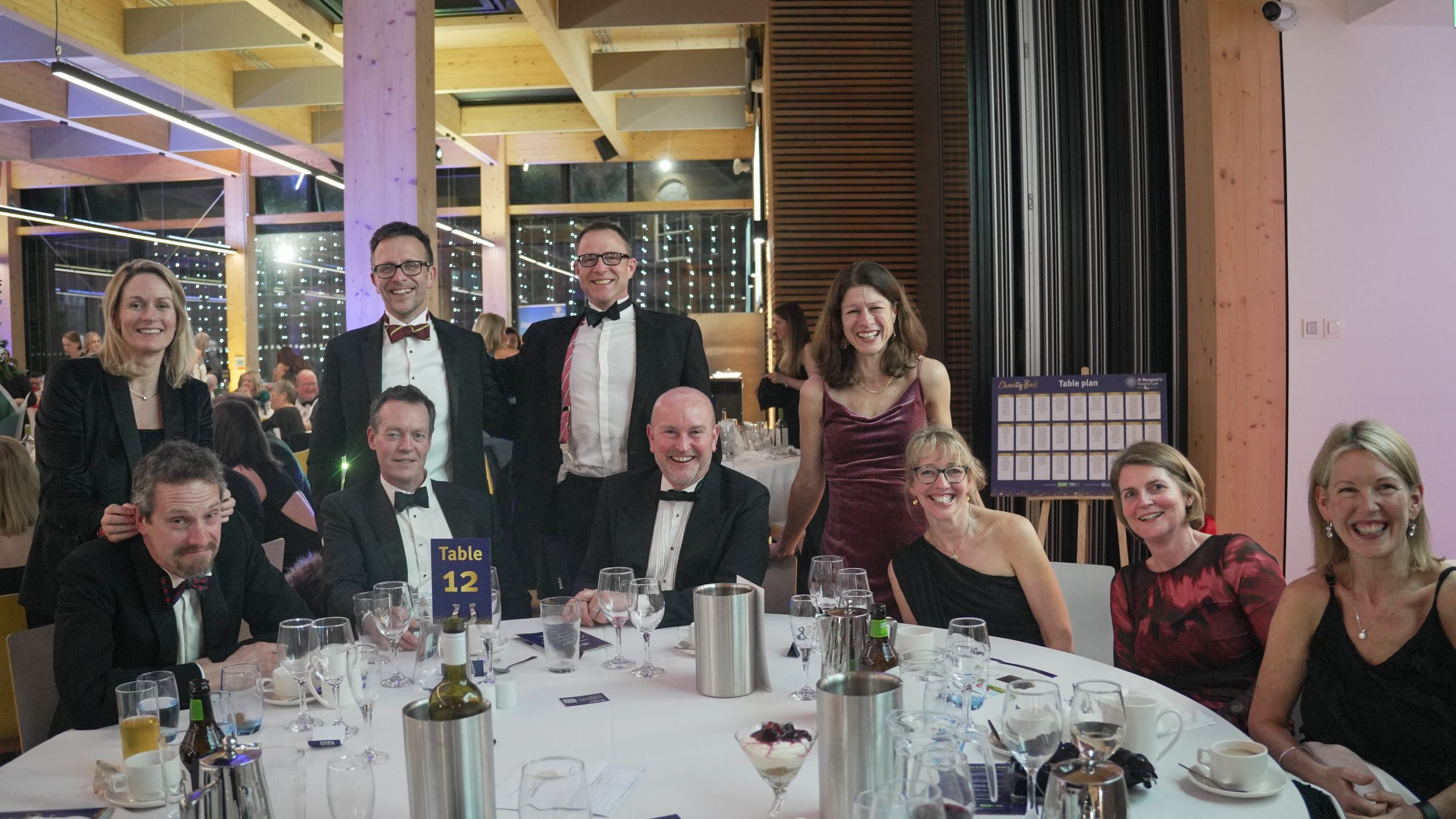 Group of people at the charity ball sit around a nicely decorated table