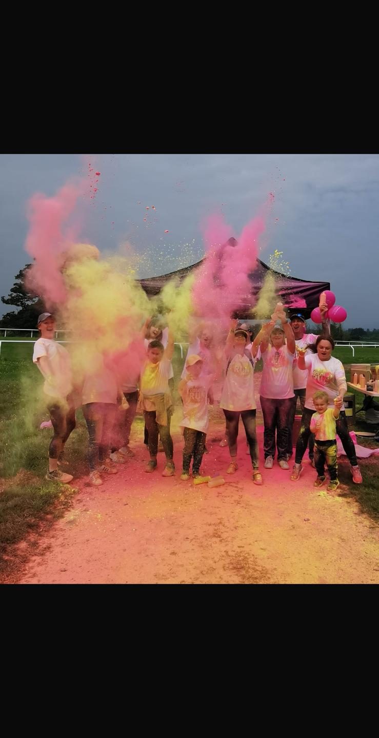 Group of volunteers throwing dry paint powder in the air