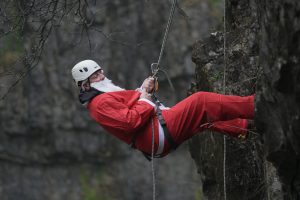an abseiler dressed in a red santa suit
