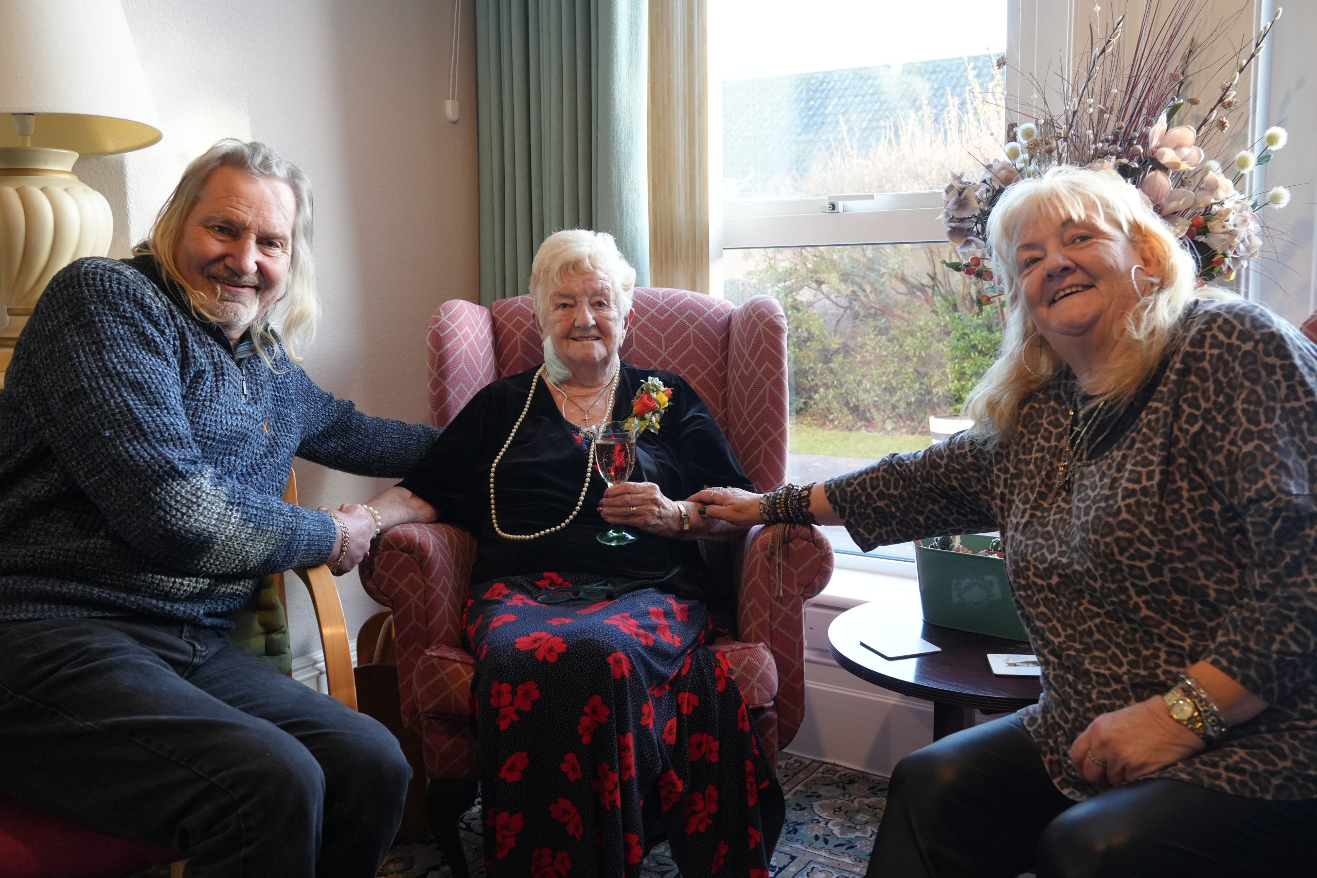 three friends sit side by side in armchairs